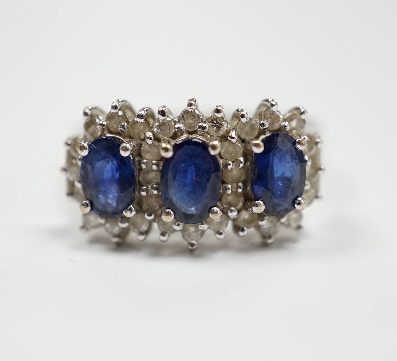 An 18k white metal, sapphire and diamond set triple cluster ring, size Q. gross weight 5.8 grams.